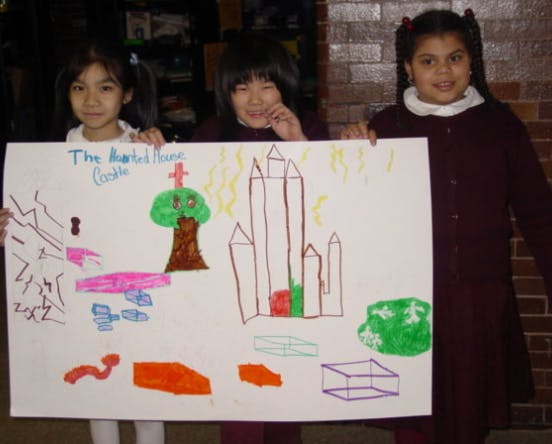 Three children holding up a drawing of a castle and a tree