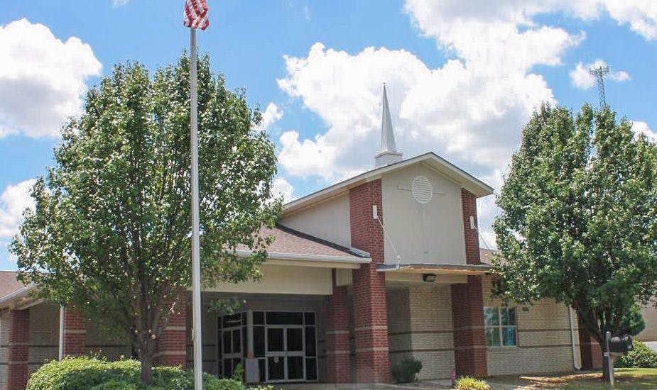 Building with a steeple and an American flag on a flagpole