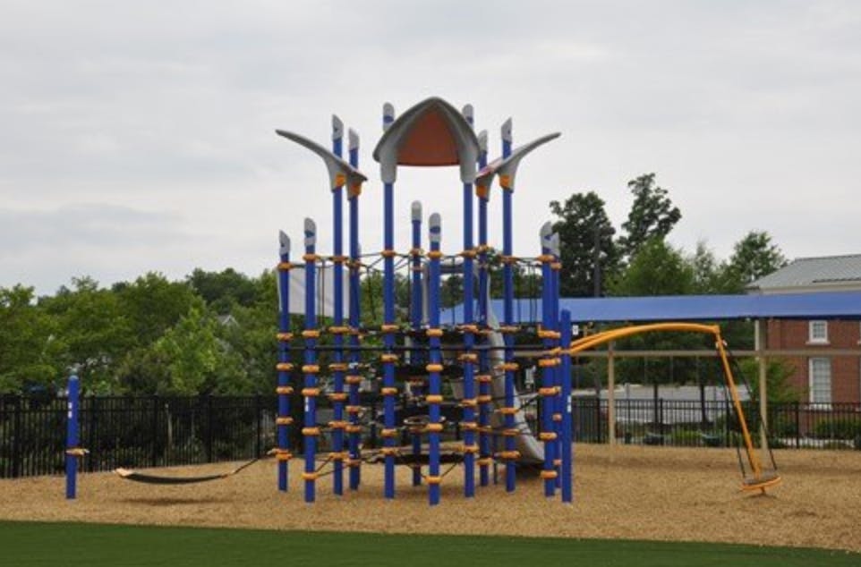 Playground with blue climbing structure and swings