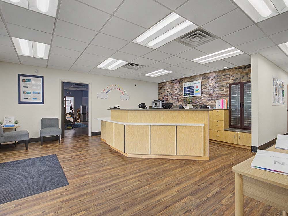 Reception desk in an office with a waiting area and wood floors