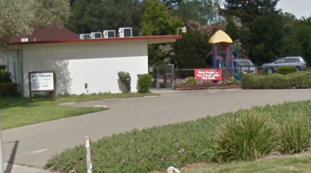 Building with a playground and cars in the background