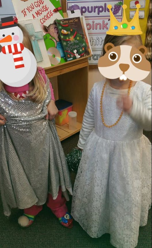 Two children in dress-up clothes, one in a sparkly dress, one in a white dress
