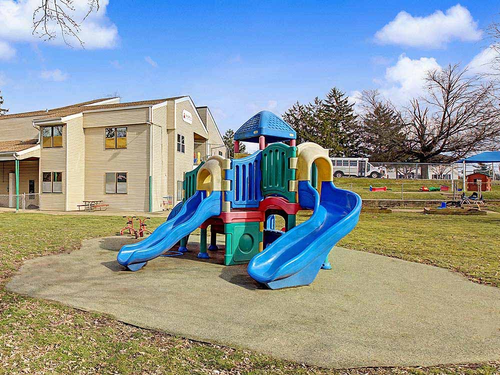 Playground equipment with slides in front of a building