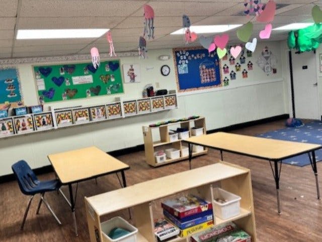 Empty classroom with small tables and chairs, and decorations