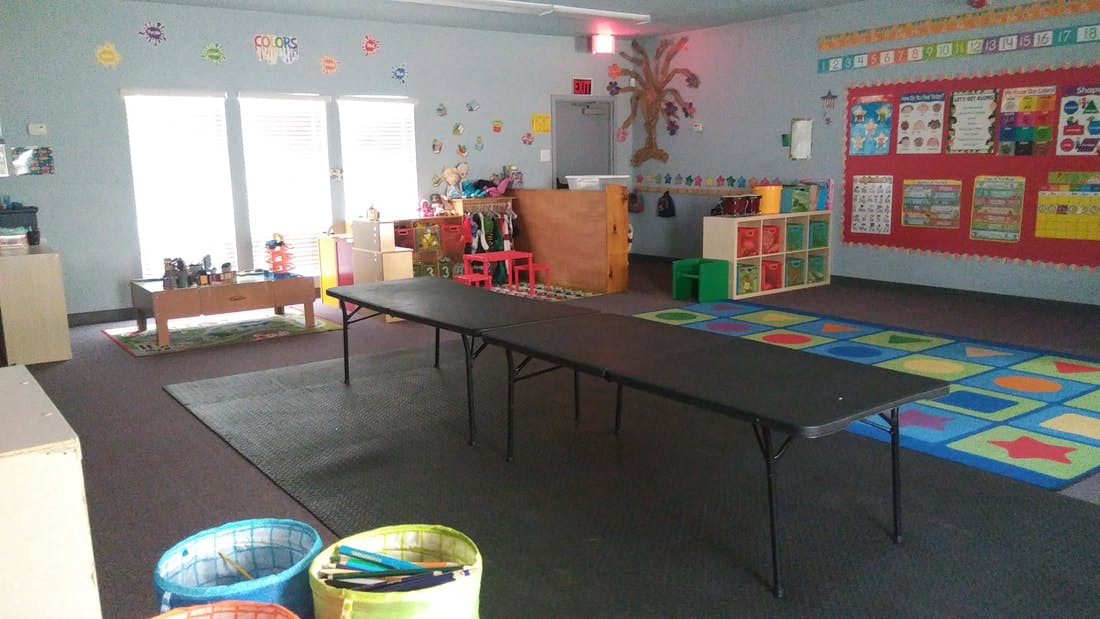 Empty classroom with long table and colorful rug