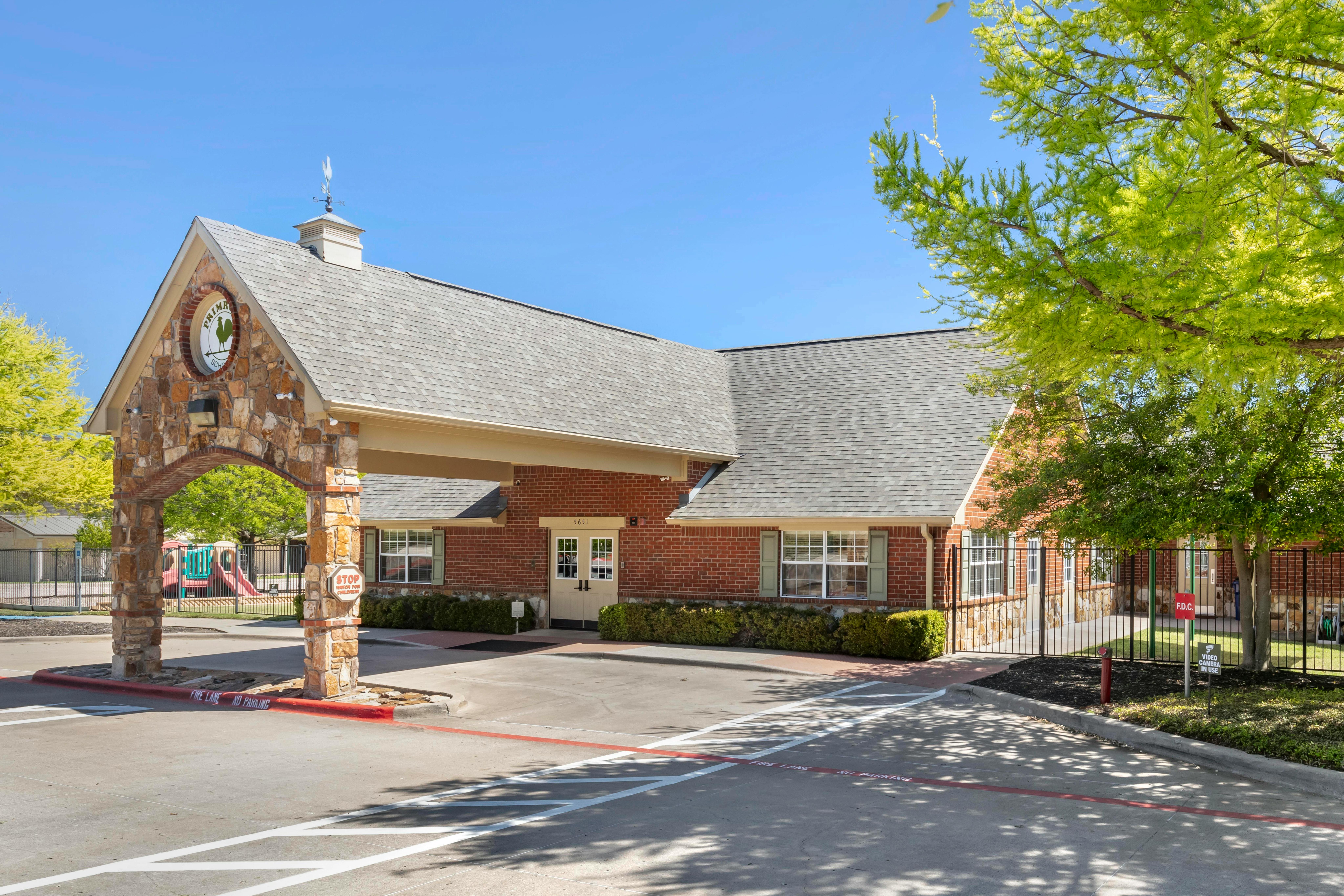 Brick building with a stone archway entrance and a primary school sign