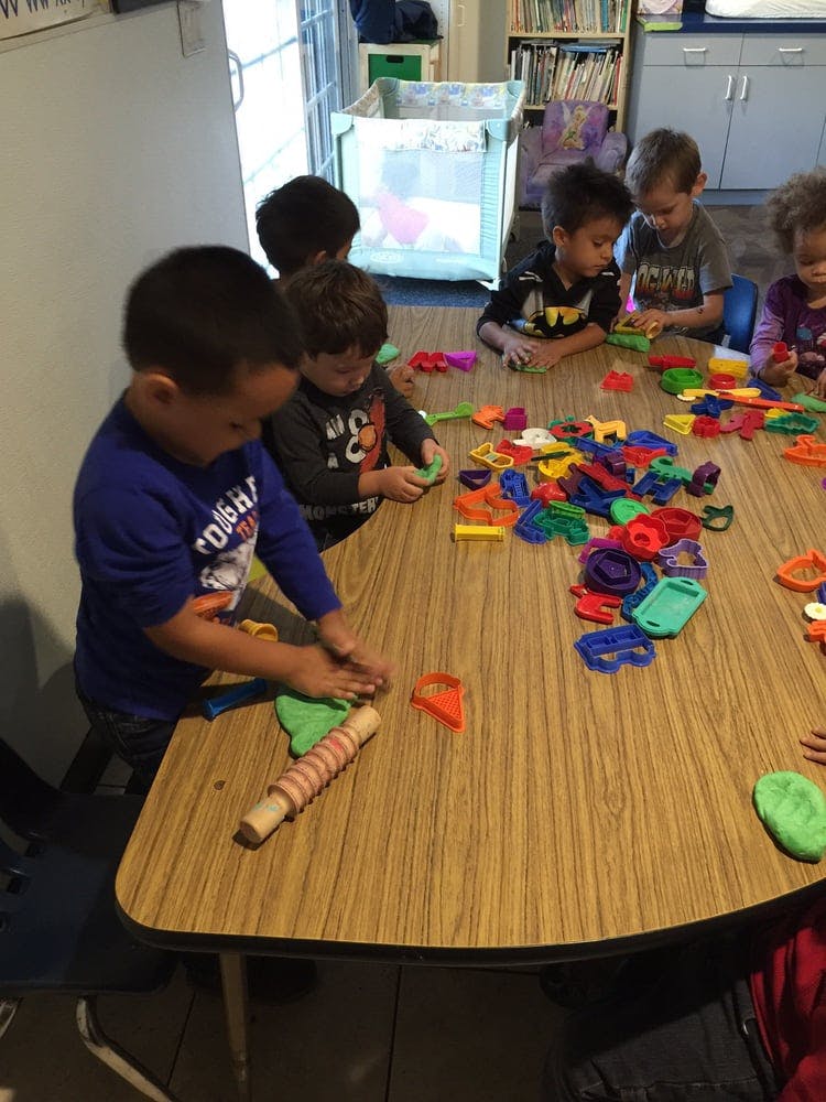 Children playing with colorful toys and modeling clay at a table