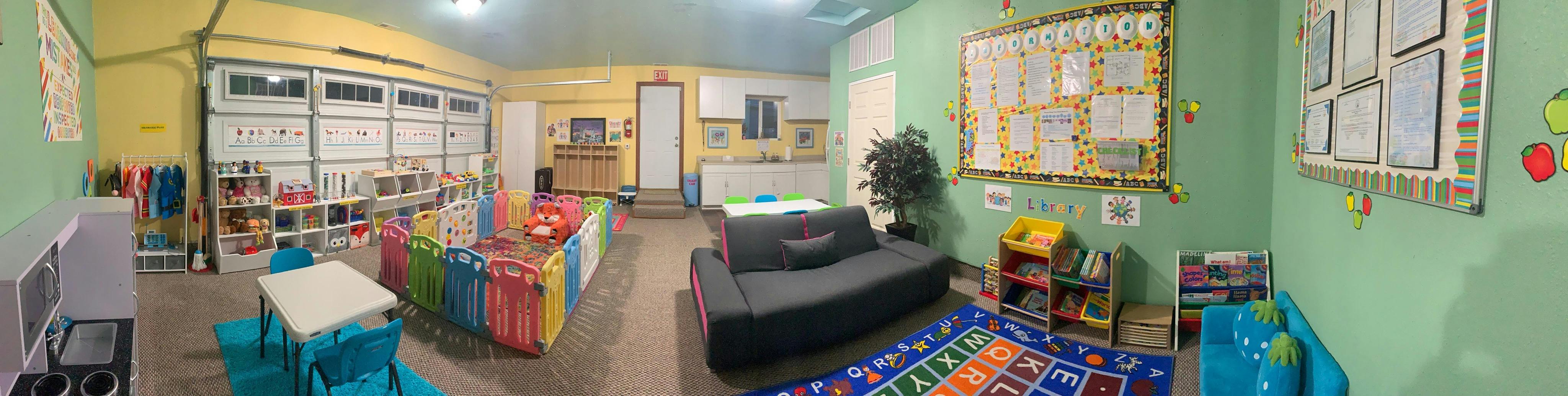 Playroom with colorful toys, small tables, and a dark sofa