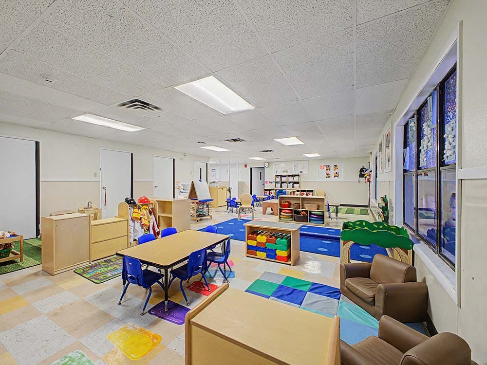 Empty colorful children's classroom with small tables and chairs