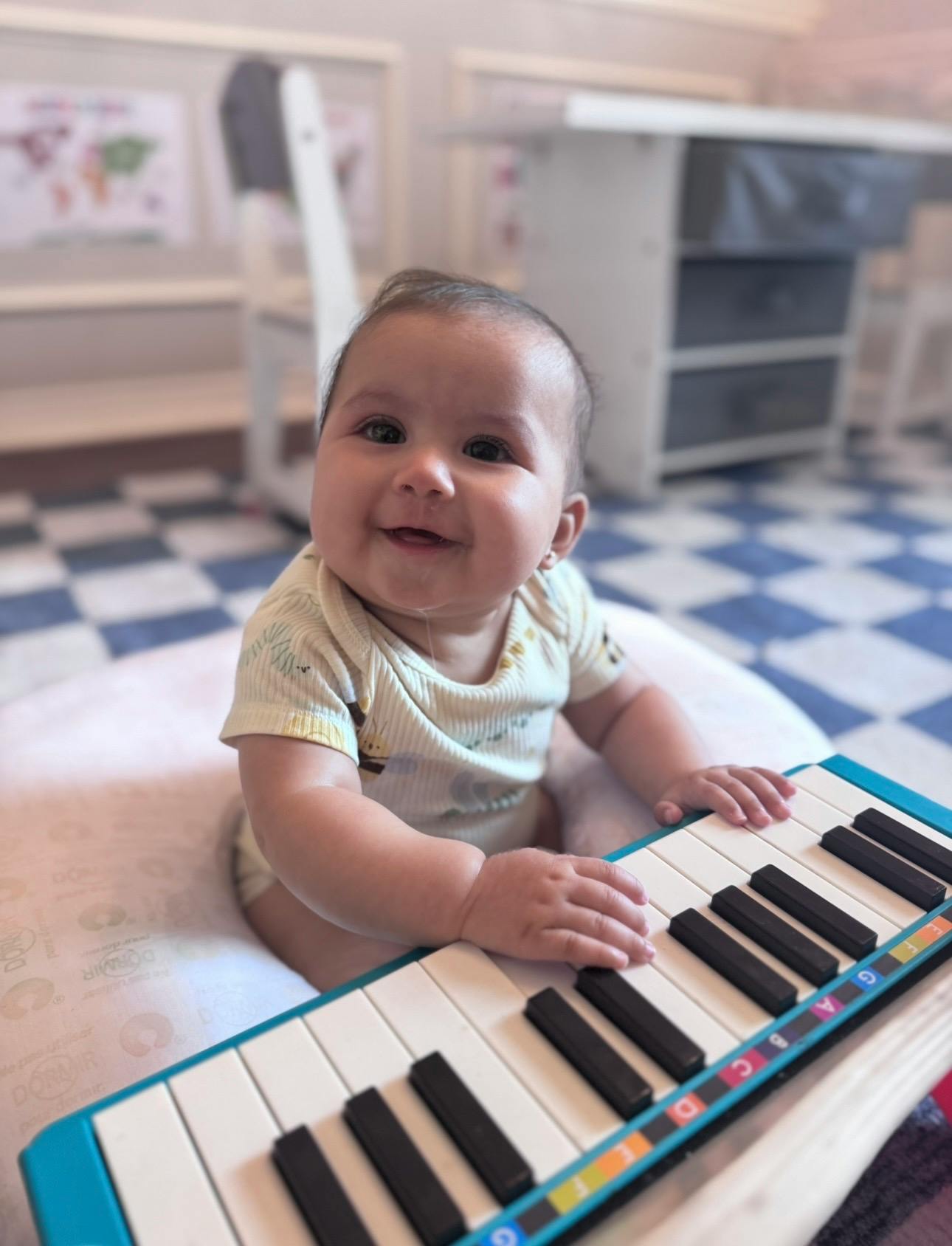 Smiling child playing a toy piano