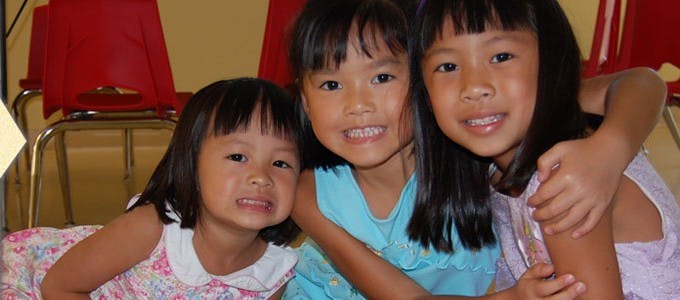 Three children smiling and posing together