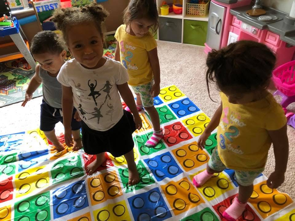 Children playing on a colorful mat