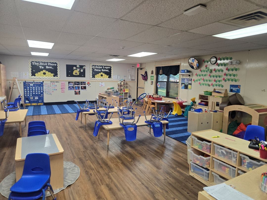 Empty classroom with tables and chairs stacked upside down