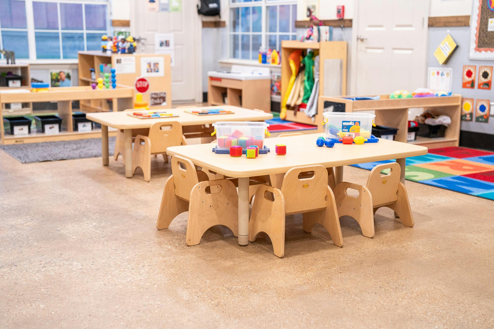 Wooden tables and chairs in a classroom setting with building blocks