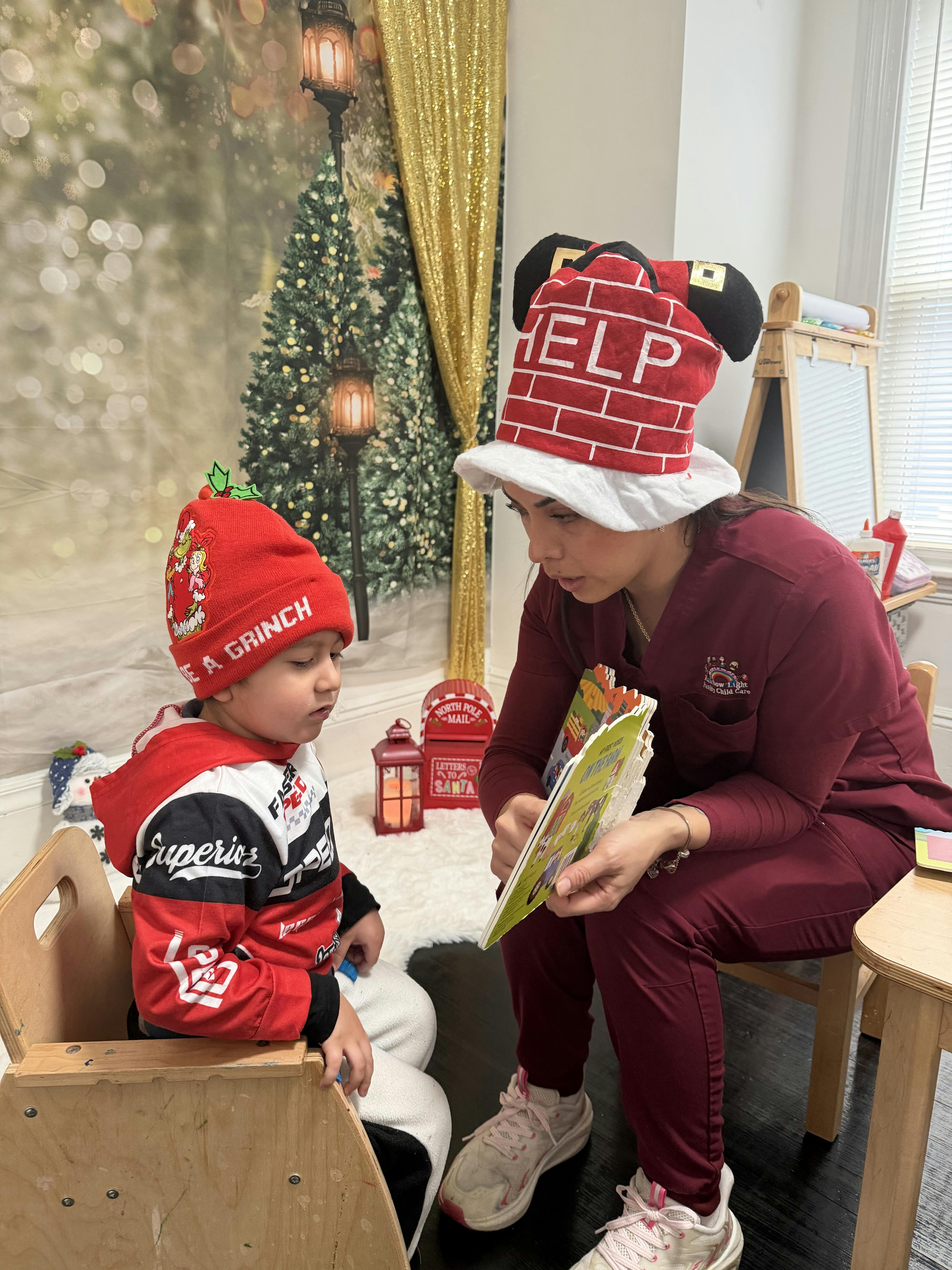 Person in a "HELP" hat reading a book to a child in a "A GRINCH" hat