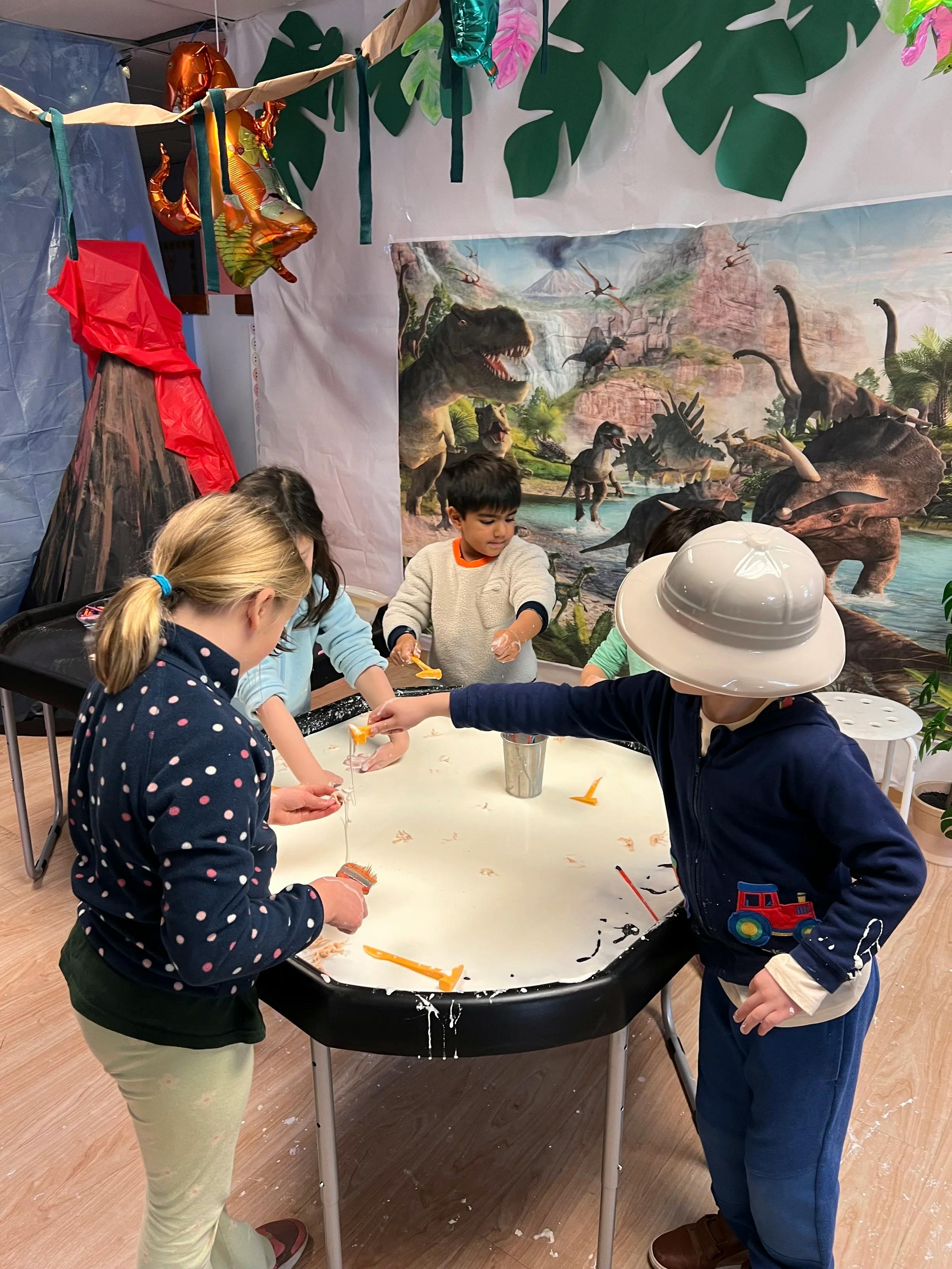 Children playing with white messy material in a sensory bin