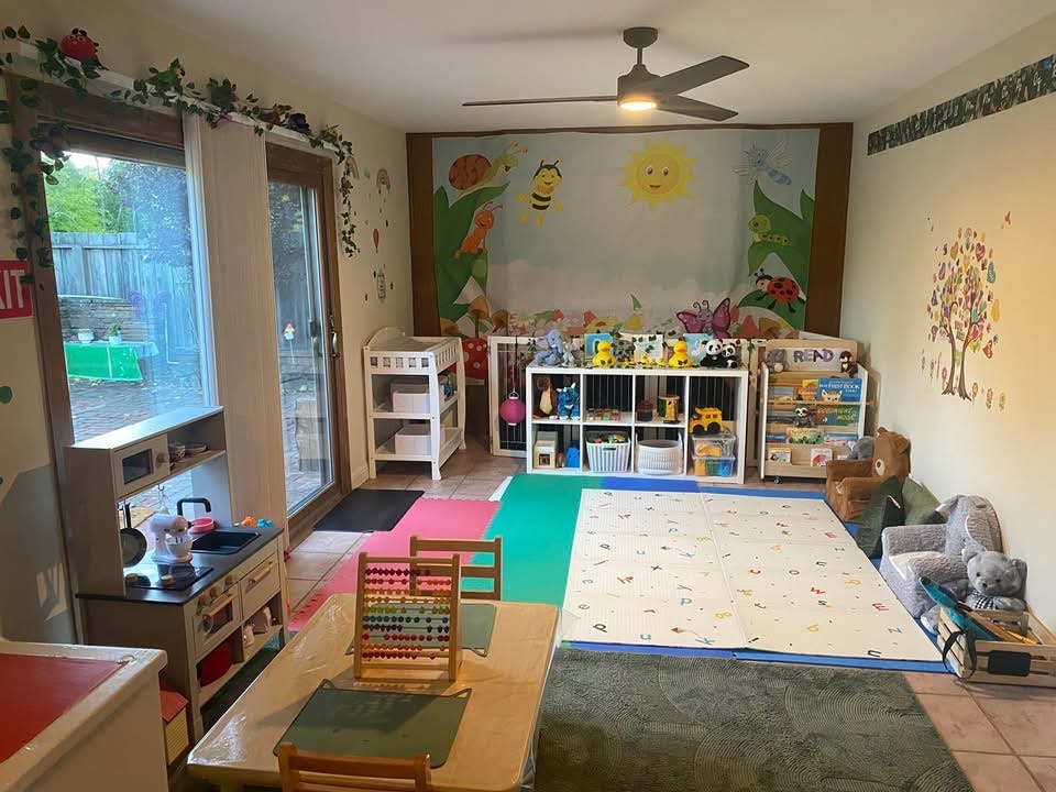 Playroom with toys, child-sized furniture, and play mats