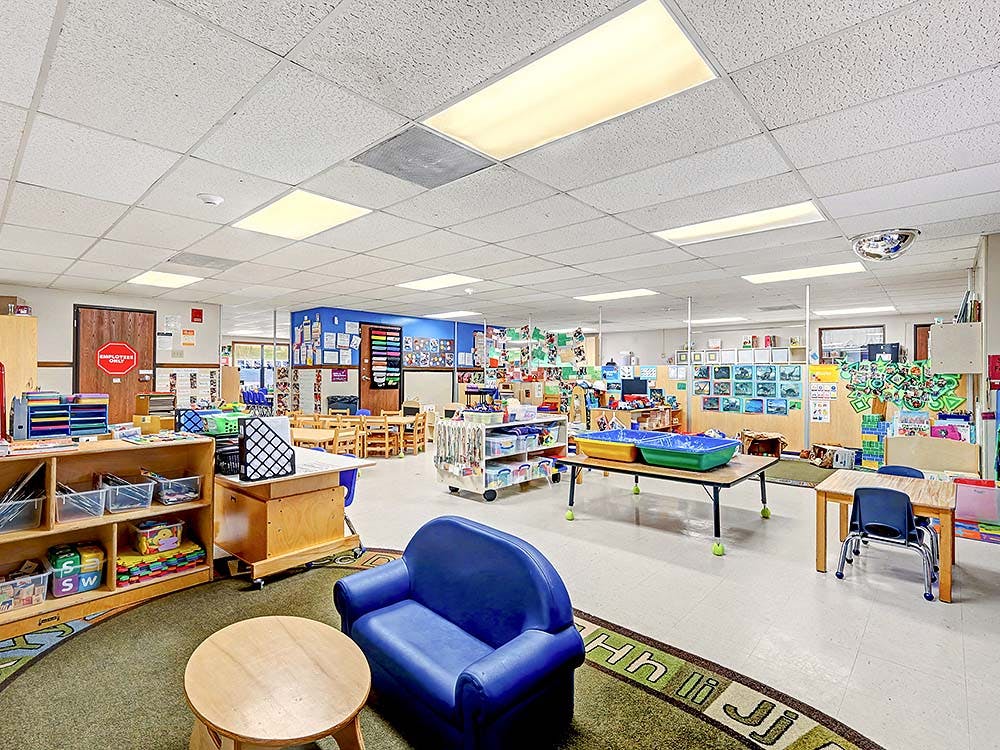 Classroom with small tables, chairs, and learning materials