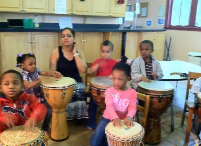 Adult and children playing drums in a drum circle