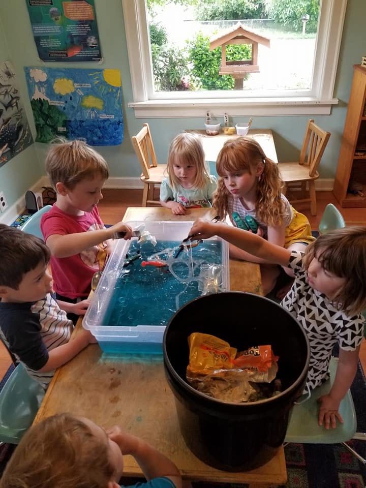 Children playing with a water sensory bin in a classroom