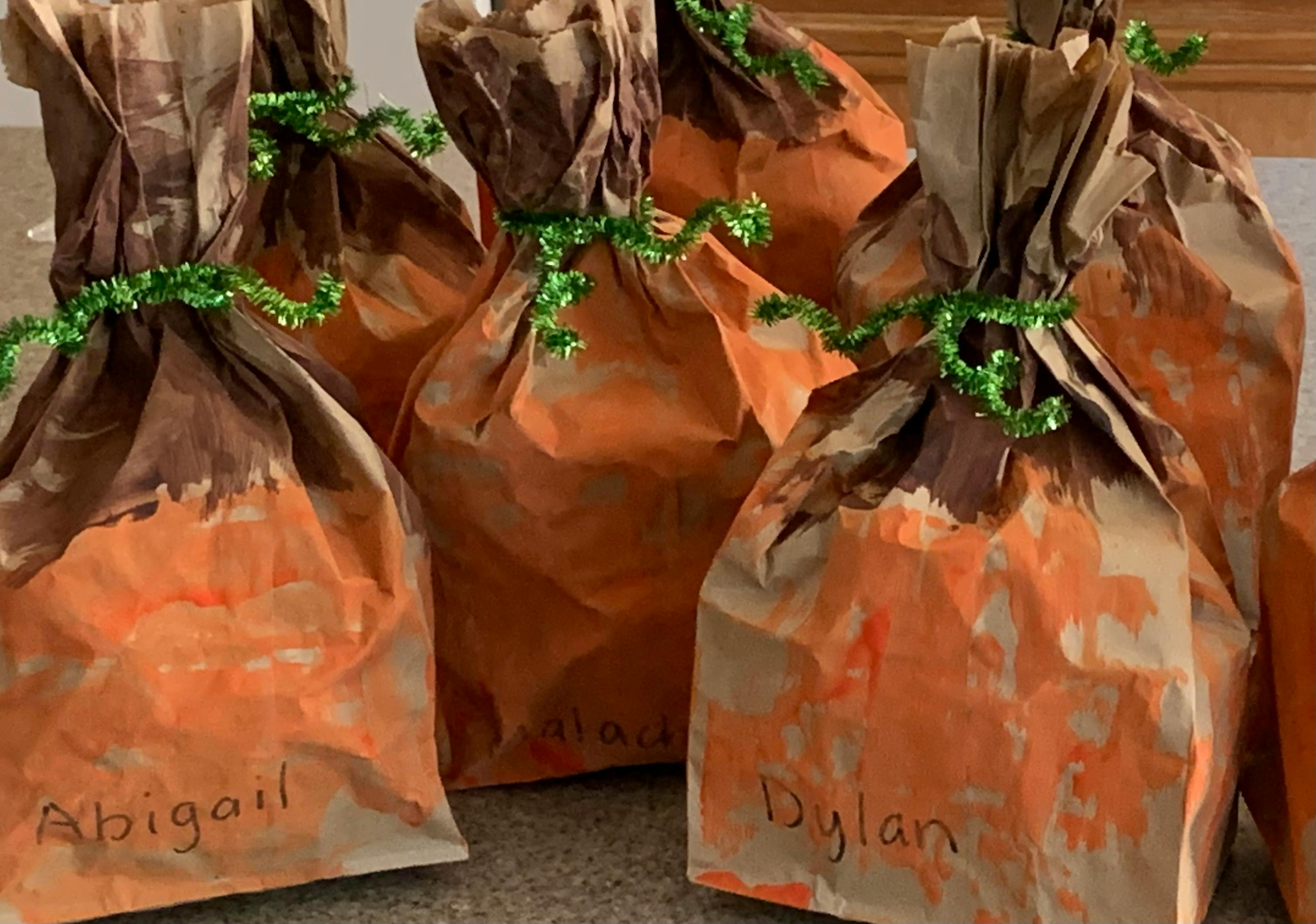 Brown paper bags with orange paint and green ties, sparkly ties