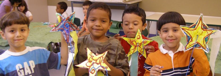 Four children holding up star-shaped crafts