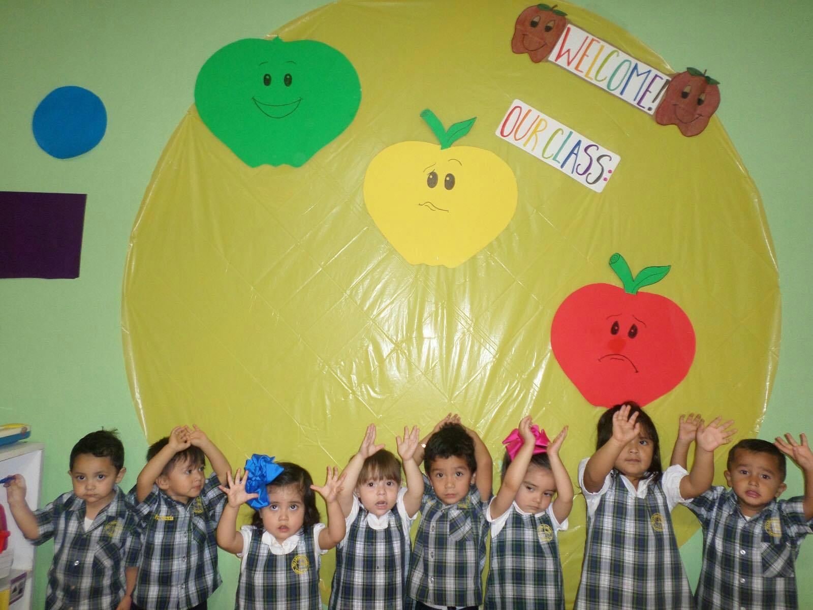 Children in plaid shirts raising their hands in a classroom