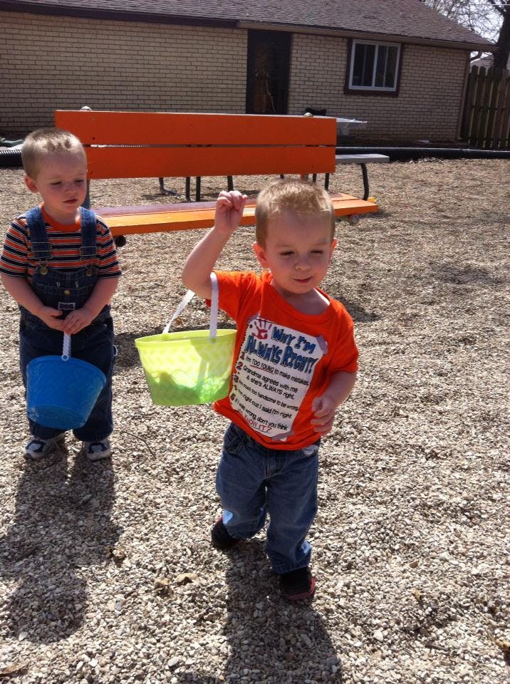 Two children holding buckets on a playground