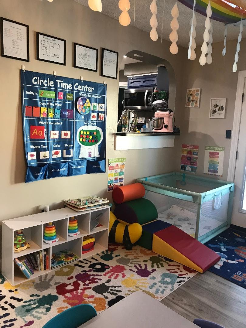 A classroom with a "Circle Time Center" chart, playpen, and colorful rug