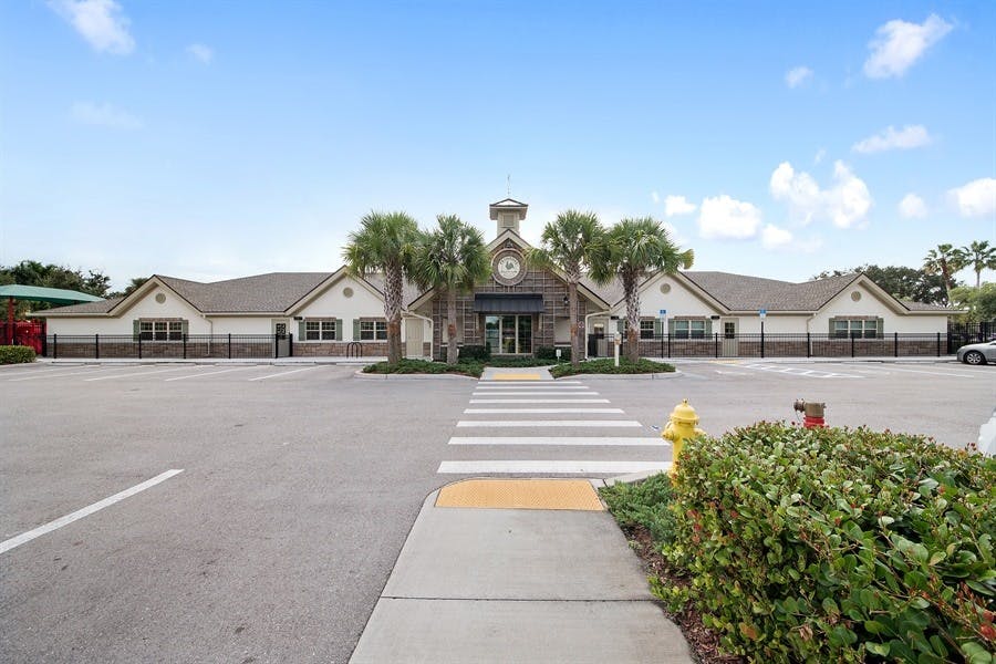 Building with a clock tower and a parking lot with a crosswalk