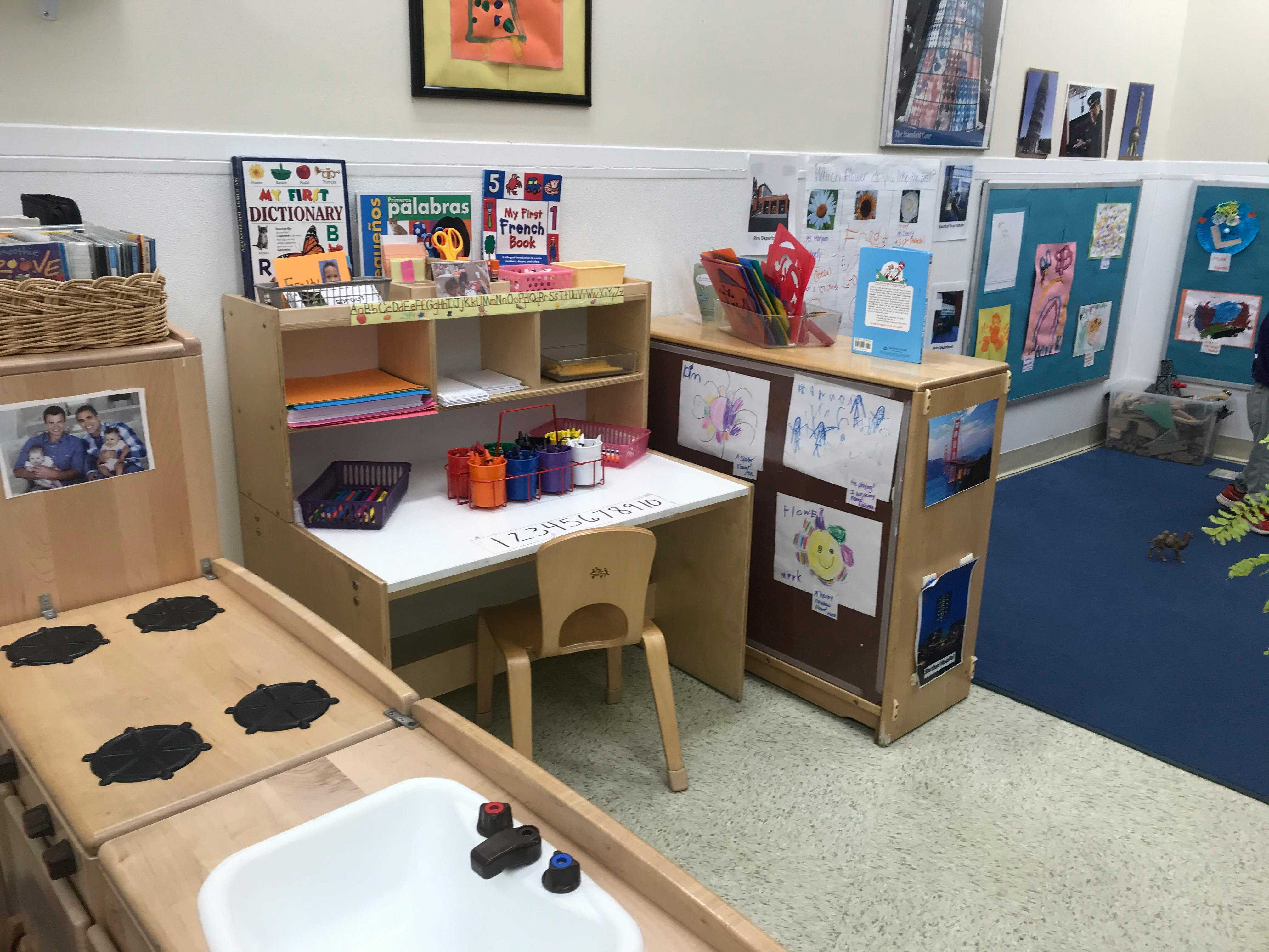 Child's desk and chair in a classroom with art supplies and drawings