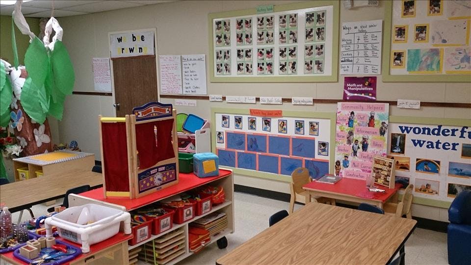 Classroom with tables, chairs, teaching aids, and a puppet theater