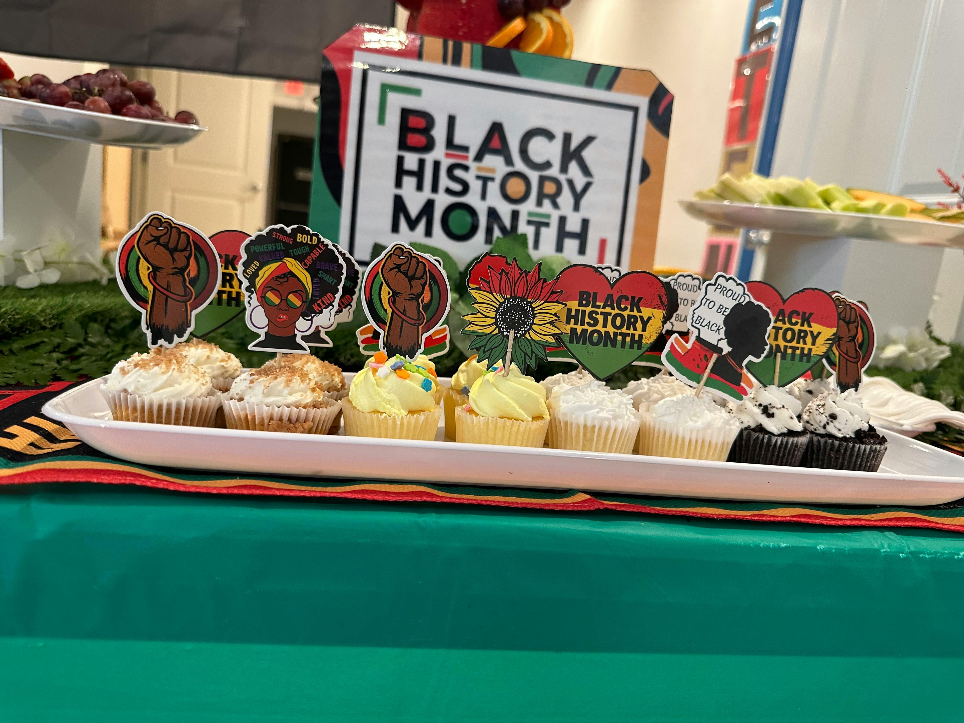 Cupcakes with Black History Month themed toppers on a white tray