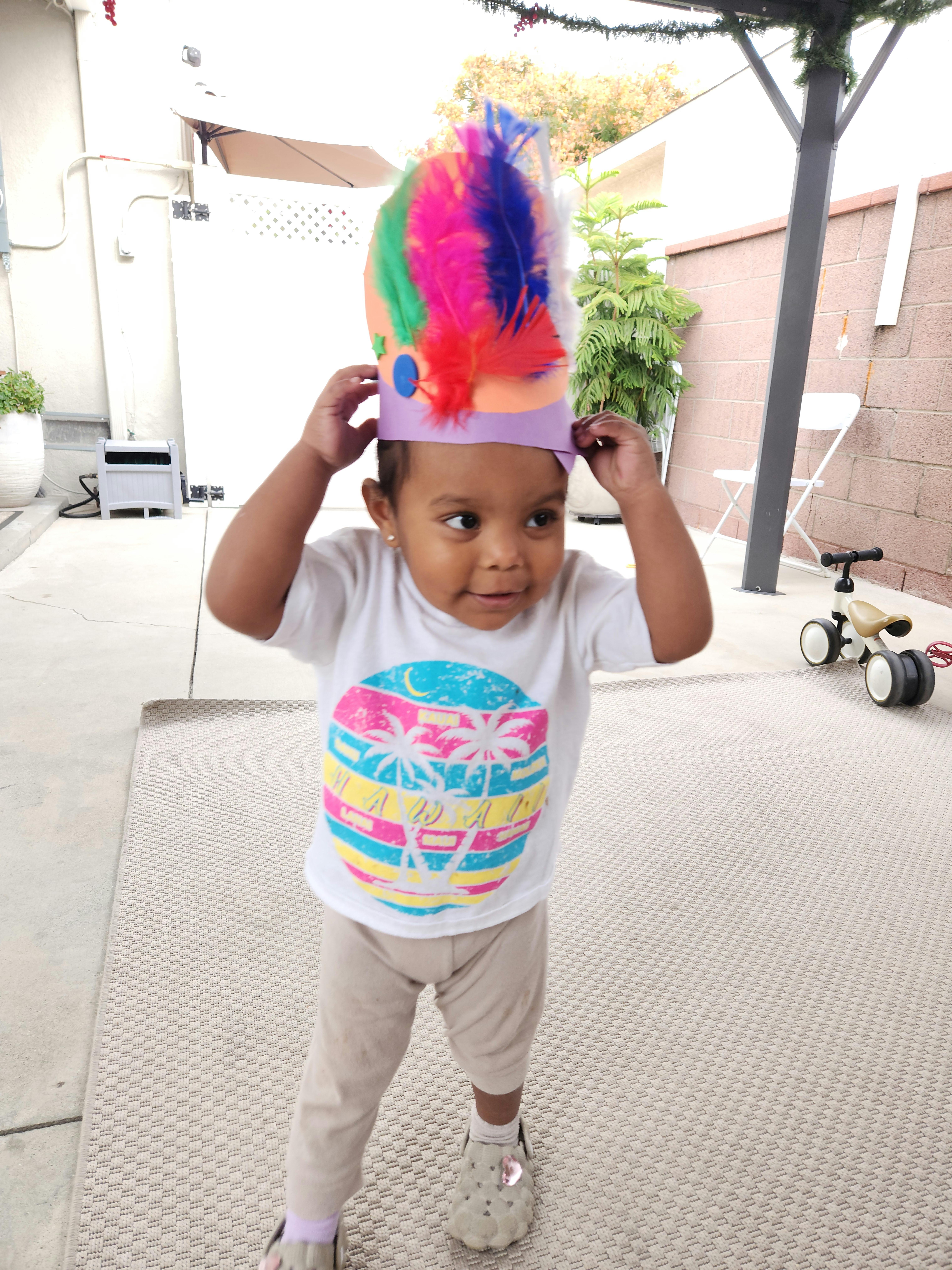 Child wearing a colorful feathered crown