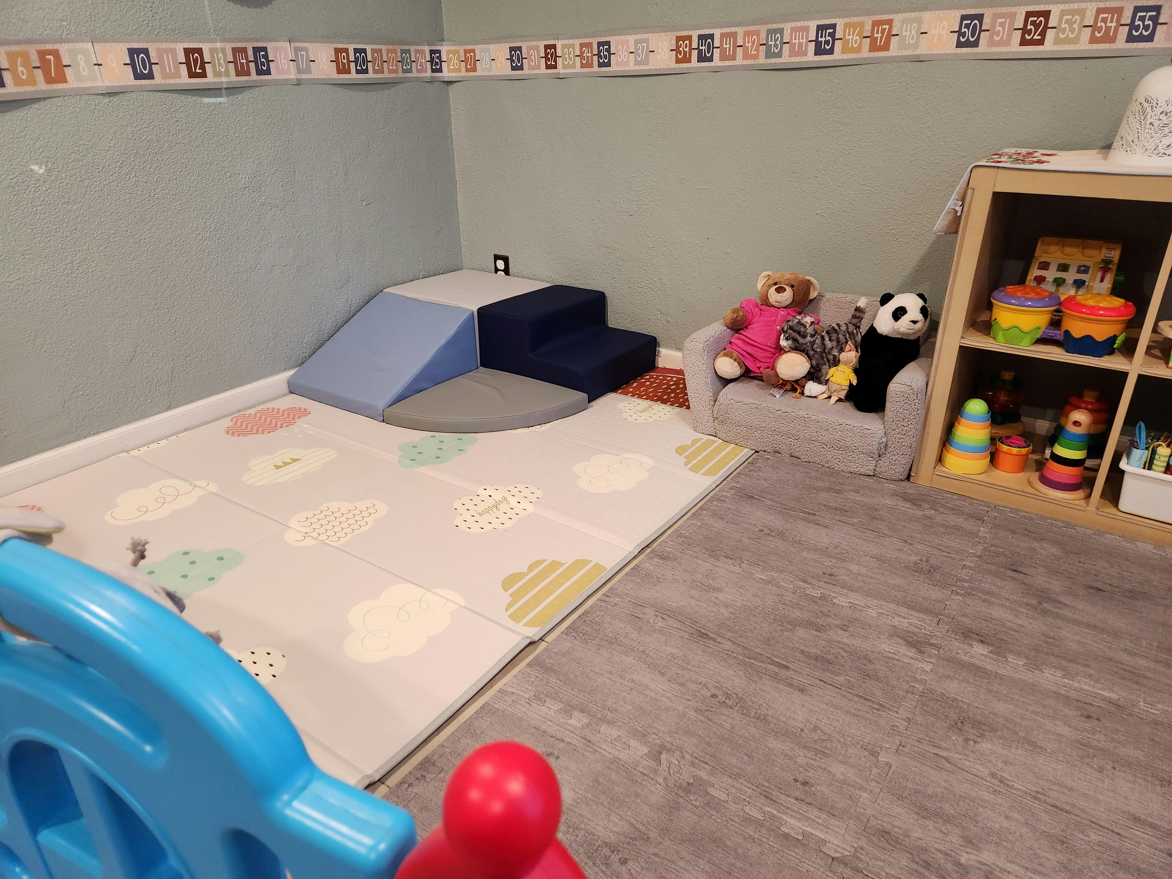 Playroom with soft play equipment, toys, and a bookshelf