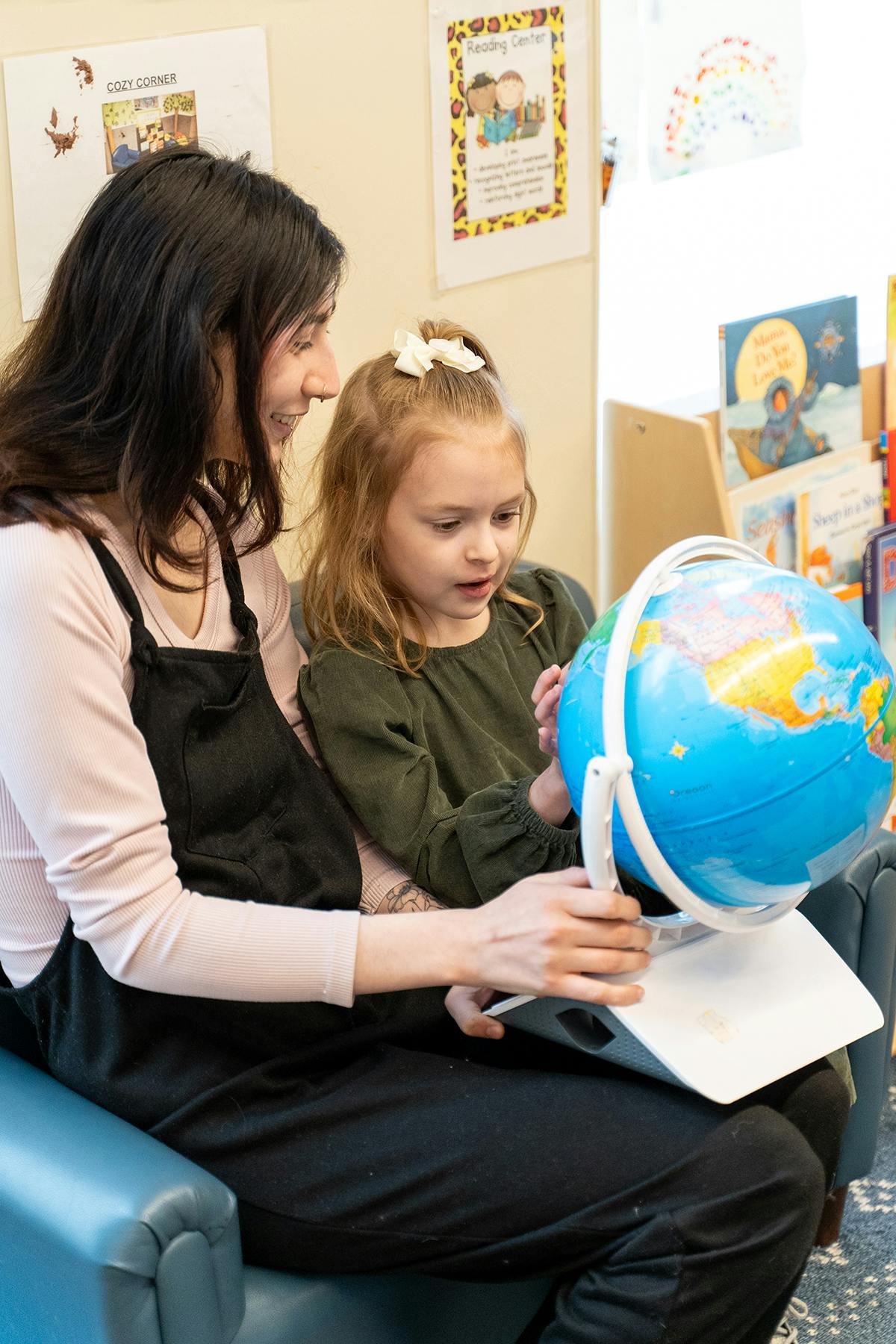 Person and child looking at a globe