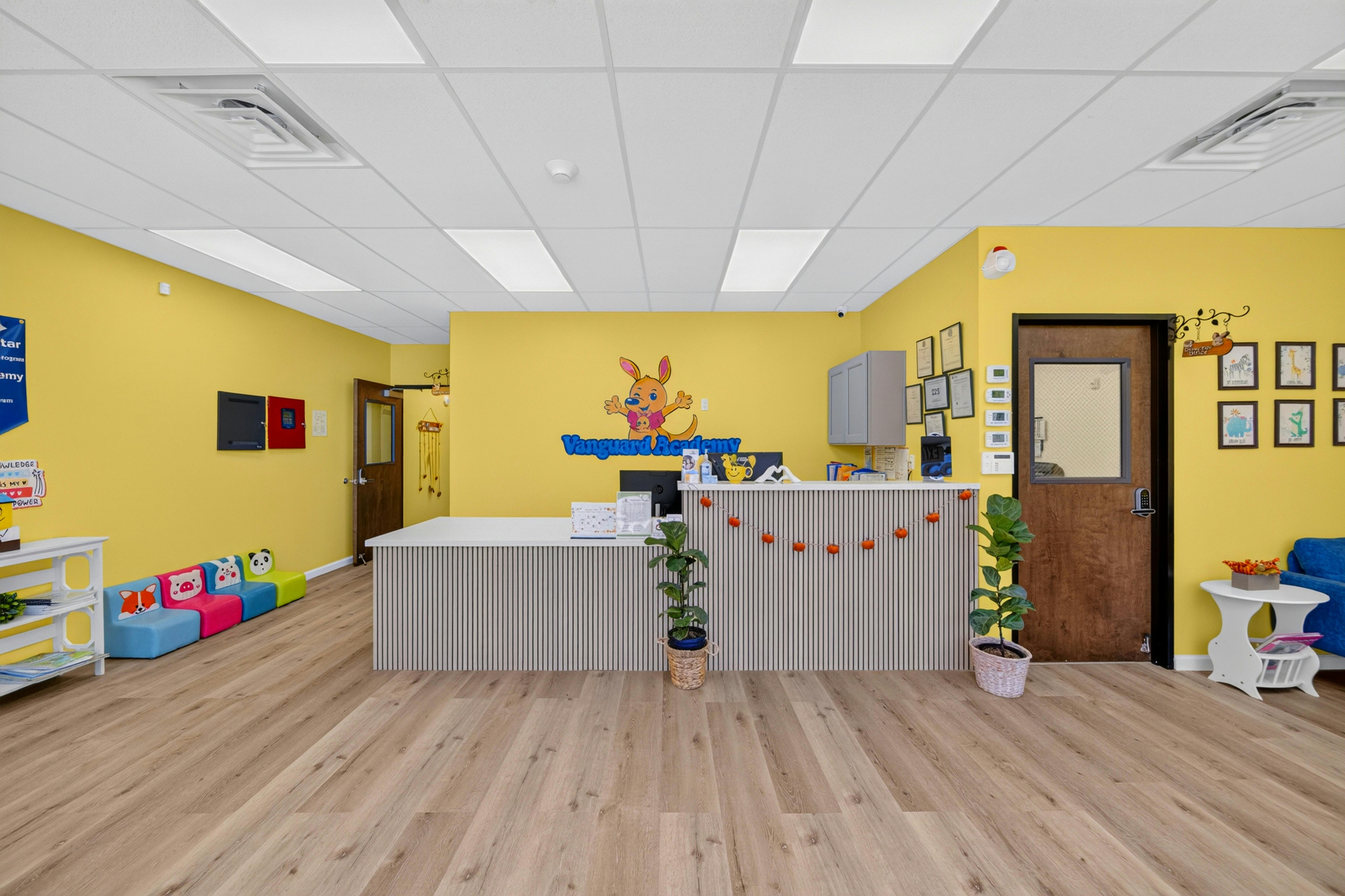 Reception desk and waiting area in a bright yellow school lobby