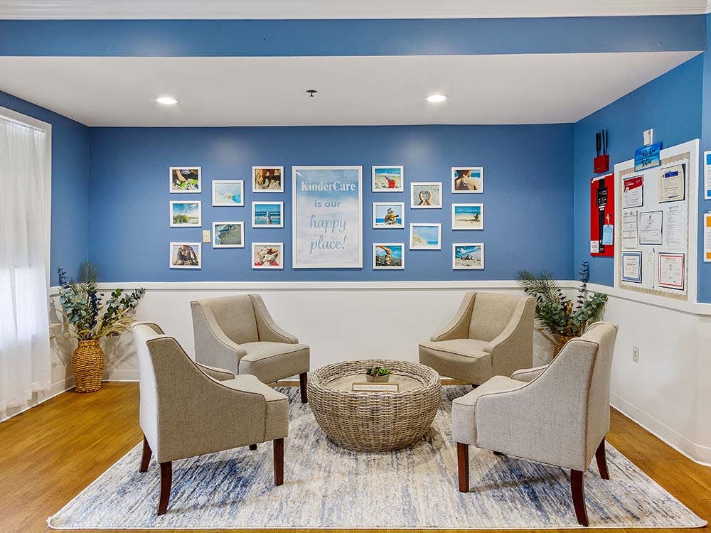 Lobby waiting area with four chairs, a round table, and photos on the wall