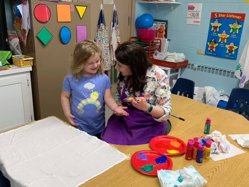 Adult and child painting together at a table