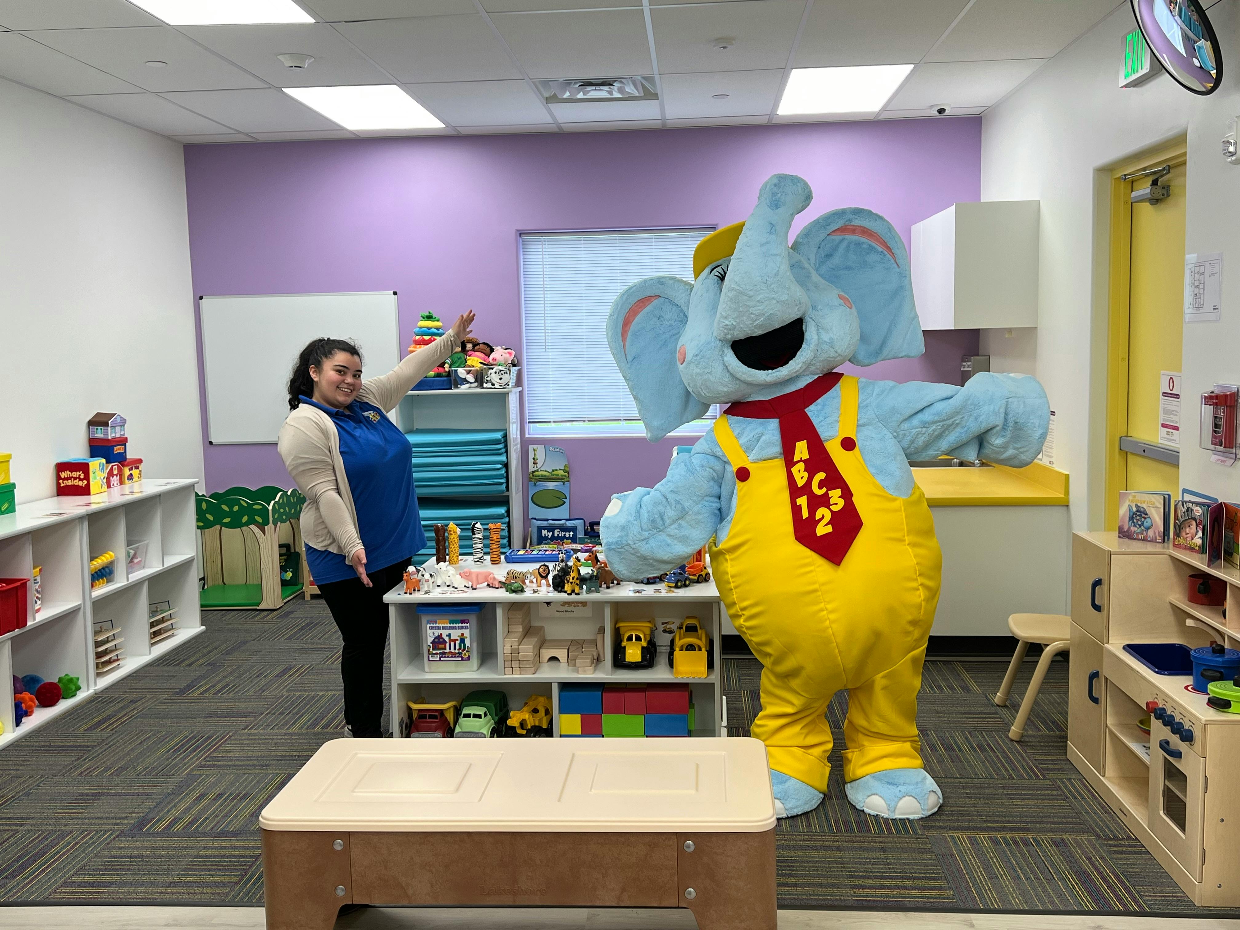 Person in a classroom with an elephant mascot