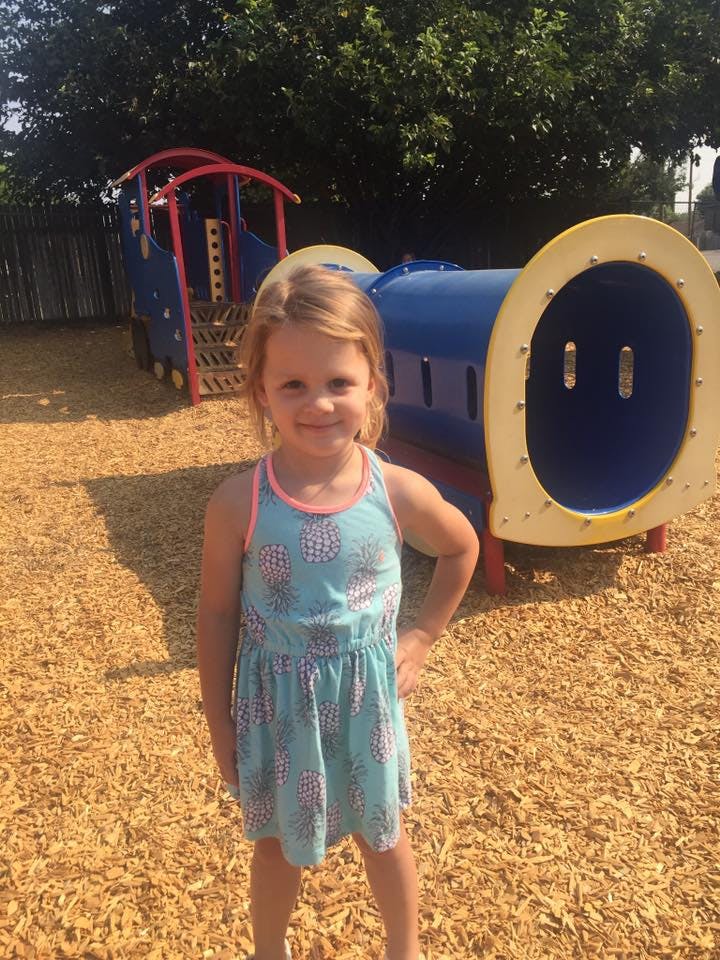 Child standing in front of a train-shaped playground structure