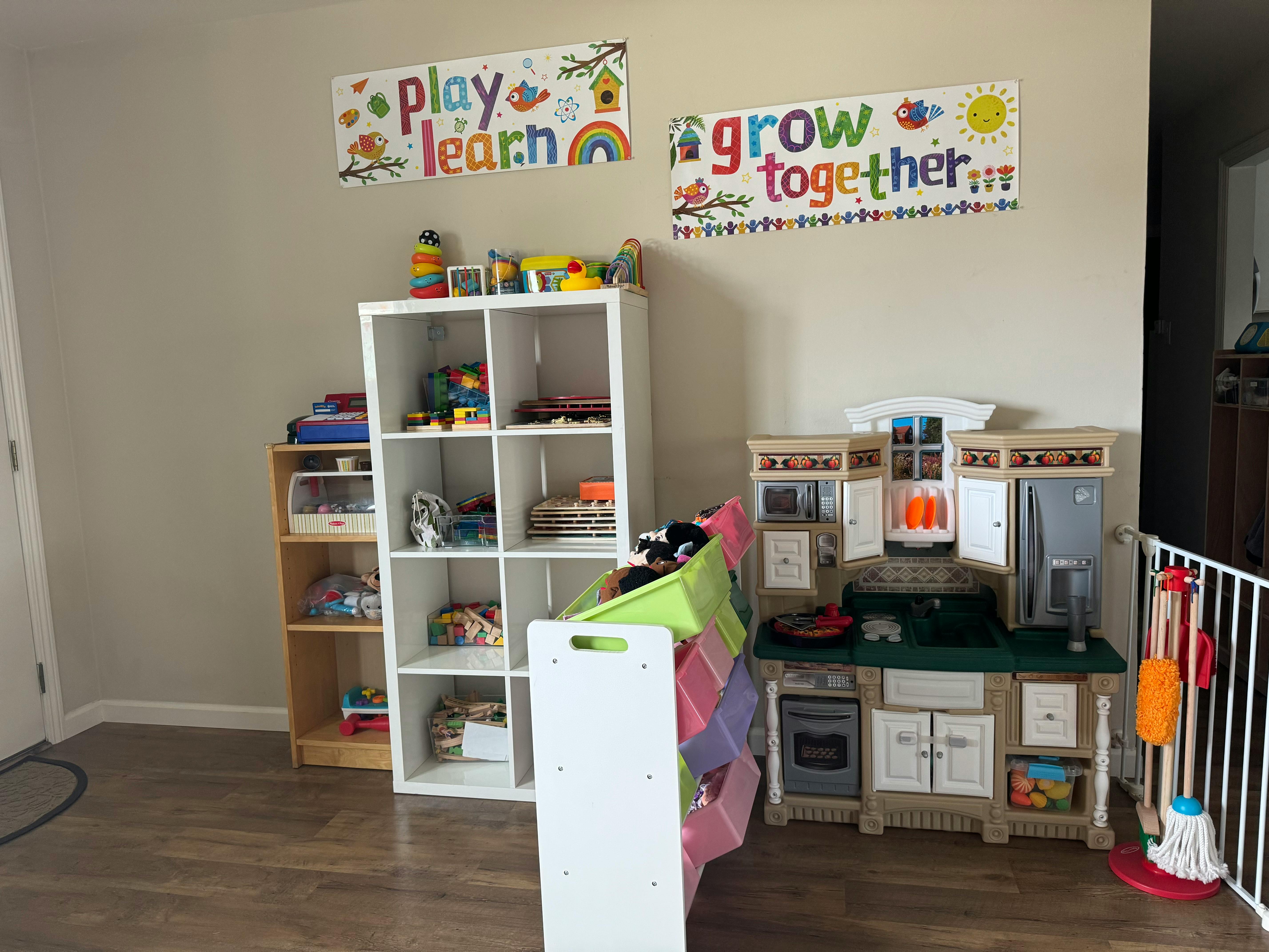 Playroom with toy kitchen, shelves, and wall decor