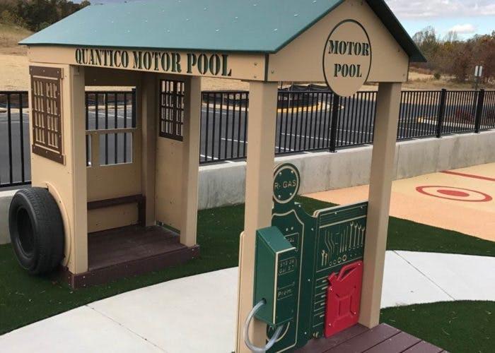 Playground structure resembling a building with "Quantico Motor Pool" text