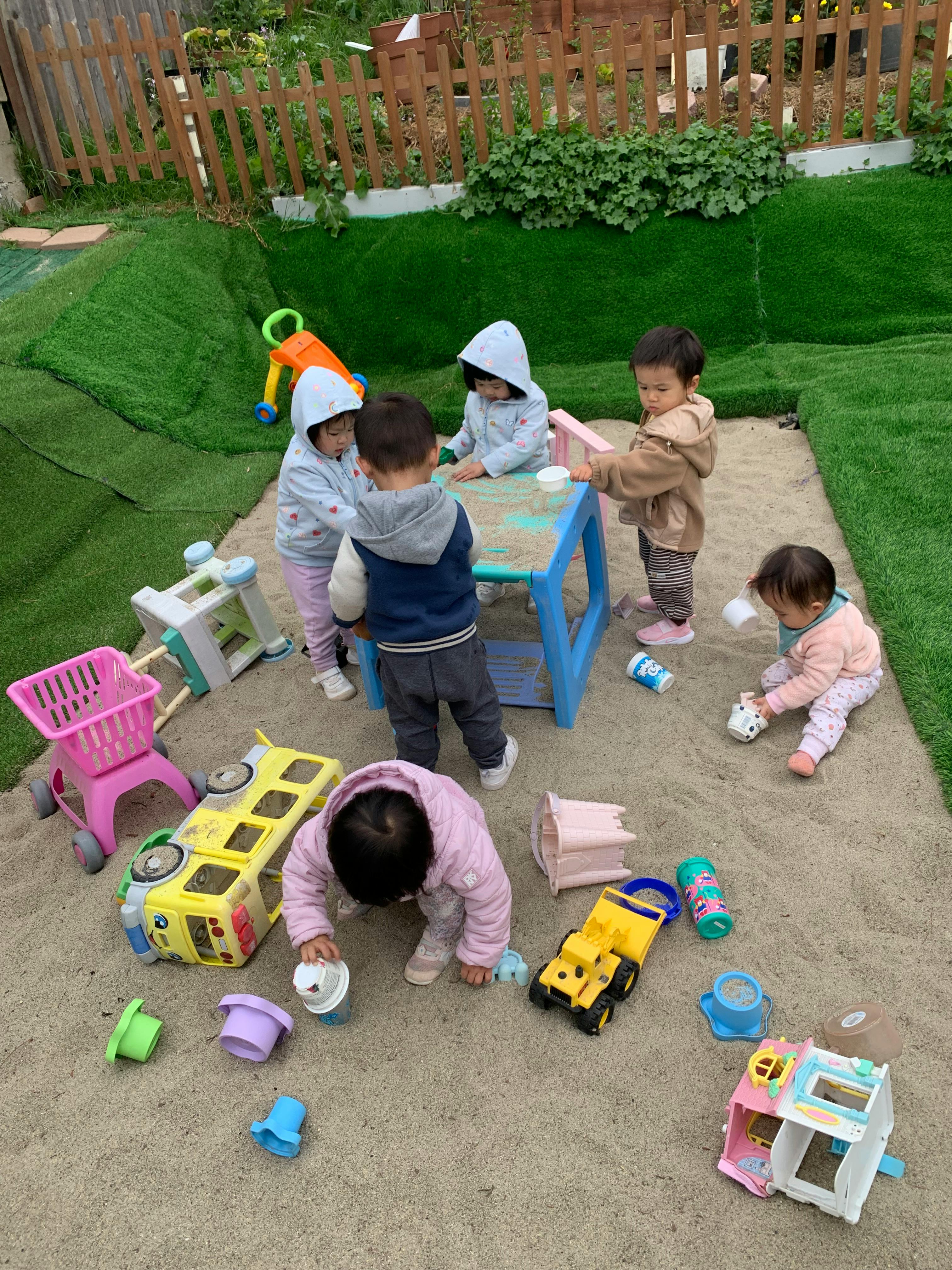 Group of children playing with sand toys in a sandbox