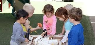 Children playing with toys in a sand and water table