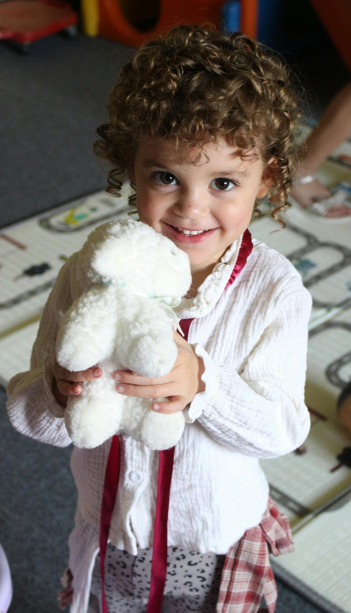 Child holding a white stuffed animal