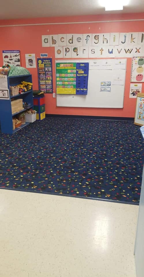 Classroom with alphabet cards, whiteboard, and blue patterned carpet