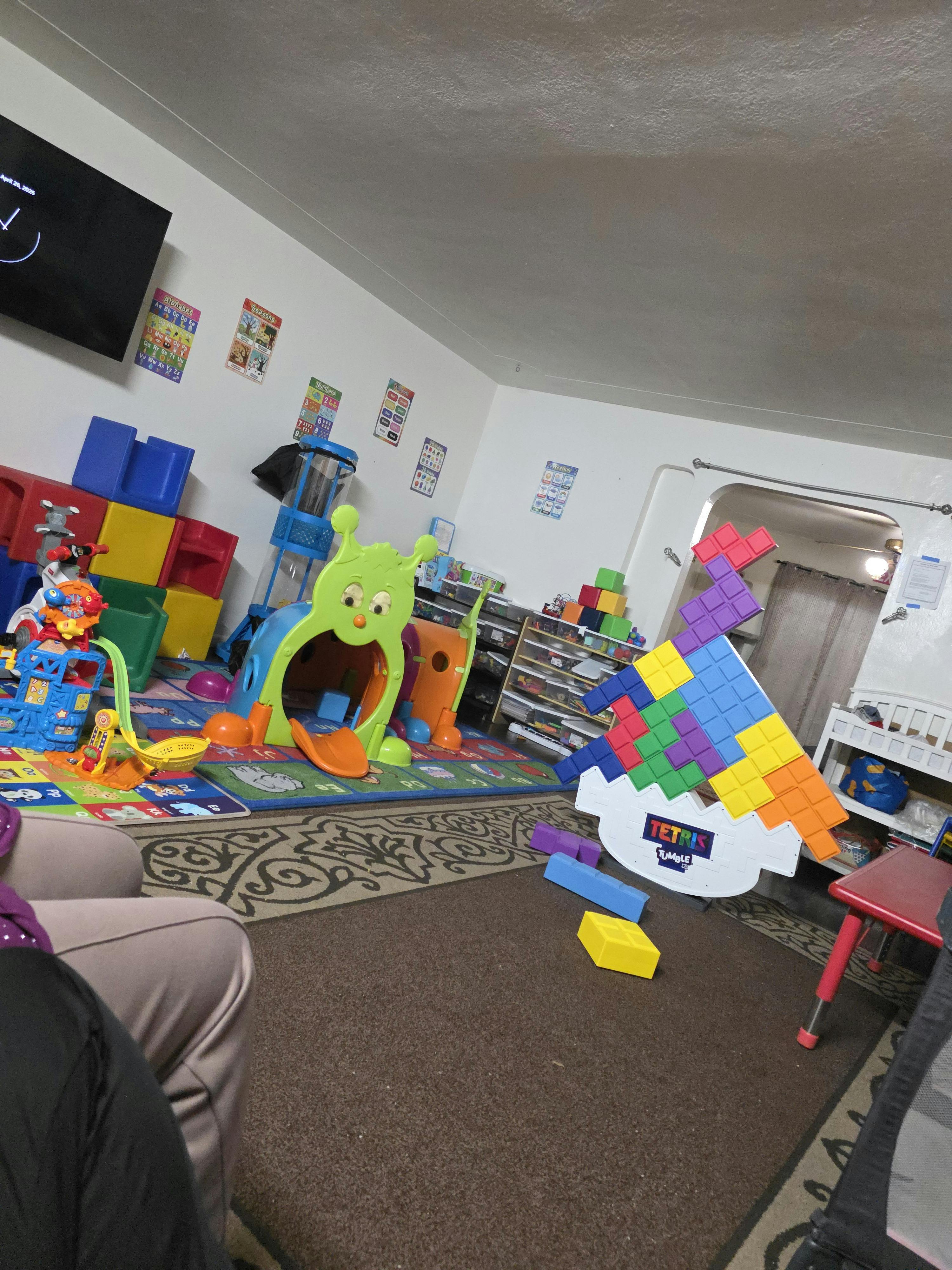 Playroom with oversized Tetris game, colorful alphabet charts, and children's toys
