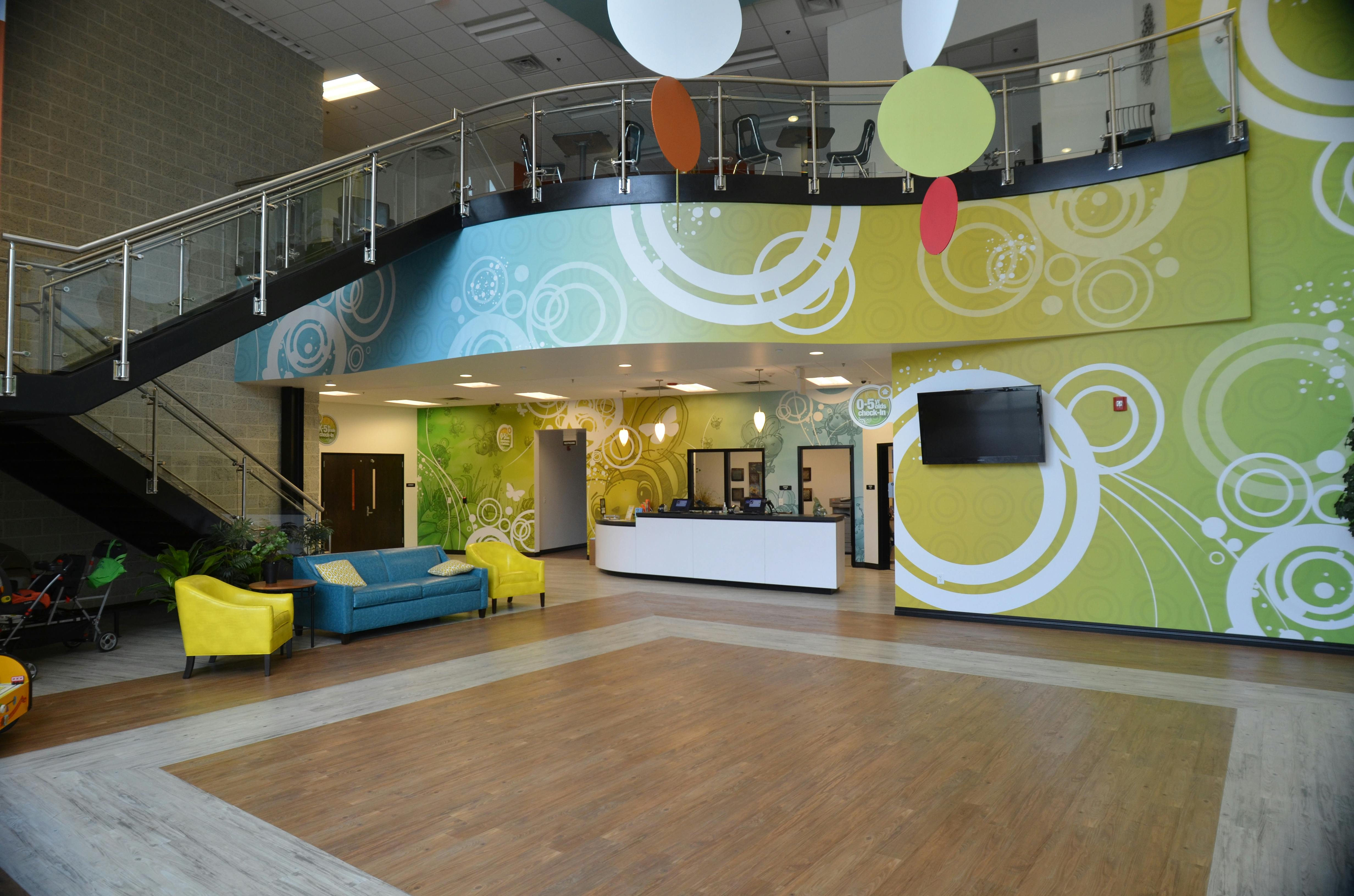 Lobby with a reception desk, seating area, and a staircase leading to a second floor