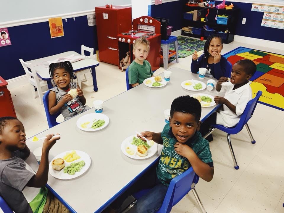 Children eating at a table in a classroom
